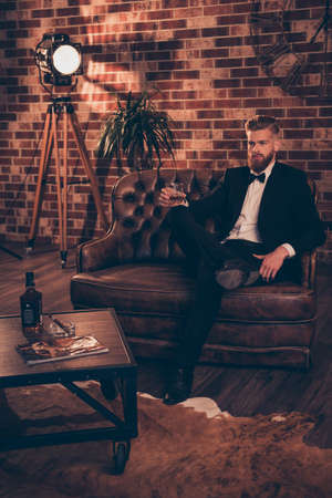 Leisure lifestyle smoke smoker ashtray bar restaurant boss chief weekend concept. Vertical full-size full-length photo of serious thinking masculine wealthy arrogant handsome guy drinking alcoholの写真素材