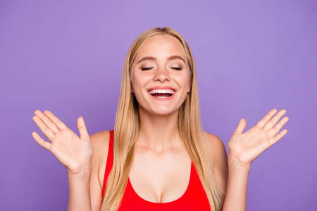 Portrait of attractive pleased blonde gorgeous girl wearing red swim suit happily clapping. Isolated over violet pastel backgroundの写真素材