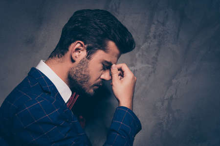Cry feeling bad unwell person people concept. Half turned faced view photo portrait of sad upset tired exhausted overworked worker touching nose bridge isolated on gray background copy spaceの写真素材