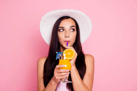 Close up studio photo portrait of thoughtful pondering with long brown hair lady holding orange...