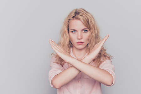 Young lovely caucasian curly-haired gorgeous strict woman showing stop denial sign. Isolated over grey background, copy spaceの写真素材
