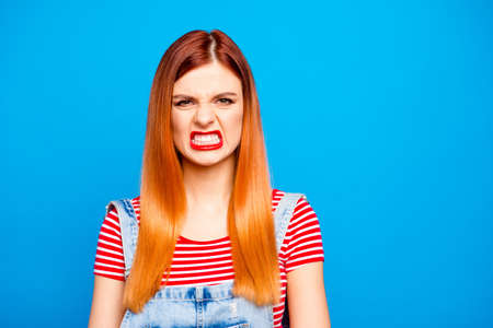 Close up photo portrait of upset dissatisfied person showing white teeth red lipstick isolated bright vivid backgroundの写真素材