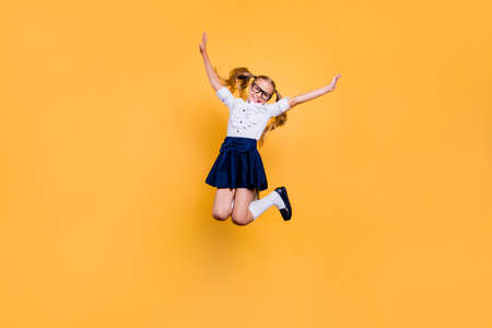 Rejoice delight enthusiasm positive laugh people person concept. Full length size studio photo of cheerful excited sweet cute clever optimistic jumping schoolchild gesturing hands isolated backgroundの写真素材