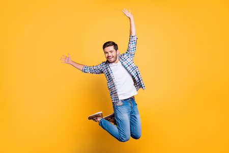 Full-size portrait of attractive well-dressed nice-looking man in jump isolated on shine yellow backgroundの写真素材