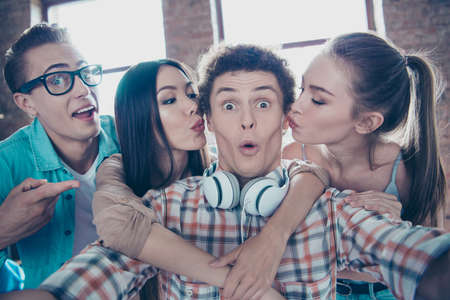 Close up portrait of cheerful youngsters make a selfie on front of the smartphone girls in casual...