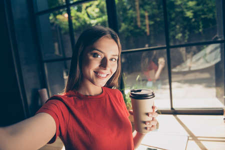 Beautiful young woman doing selfie on the front camera of her smの写真素材