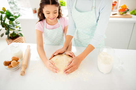 Cropped cake cooking on table, young mom and her small cute loveの写真素材
