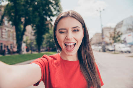 Young woman with dark hair winks and wide open her mouth shootinの写真素材