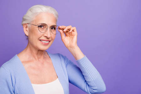 Portrait of grey haired old smiling woman wearing glasses, holdi