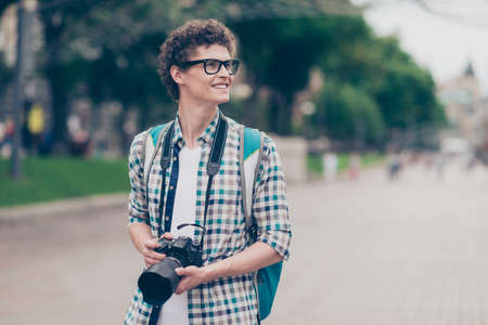 Curly haired cute attractive handsome smiling guy nerd with camの写真素材