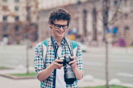 Curly haired cute attractive handsome smiling guy nerd with camの写真素材