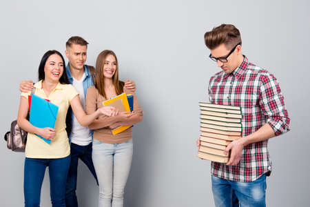 Upset guy a-student in a checked shirt keeps pile, stack of lite