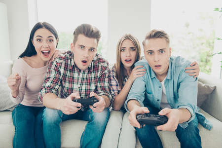 Loser or the winner Stylish, trendy youngster sit on the couchの写真素材