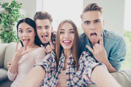 Careless group of four trandy youth make selfie on the front cam
