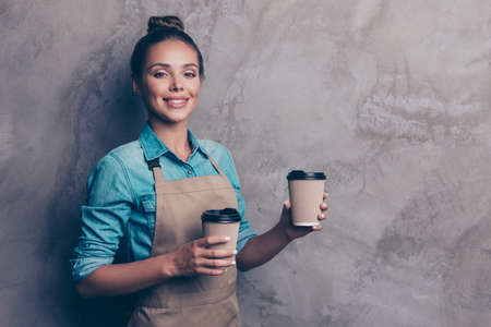 Pretty, dreamy, charming girl holds disposable cup with drinks aの写真素材