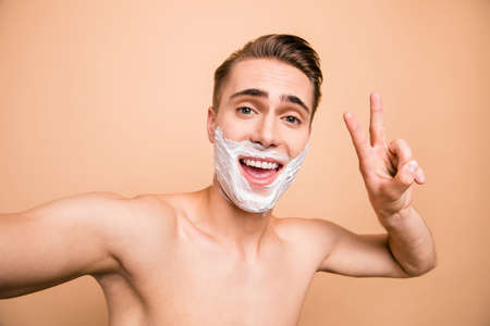 Portrait of carefree, careless, rejoice man in foam for shave onの写真素材
