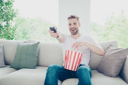 Close up portrait of attractive, brunette bristle man watches TV