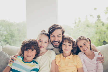 Close up of a father with his childrens sitting on the sofa