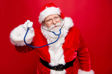 Worried calm Santa look at camera hold stethoscope in hand standの写真素材