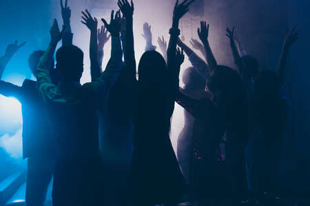 Cheering celebrity super star concept. Photo of many people enjoying concert raised hands up dancing in nightclub, night entertainment, music festivalの写真素材