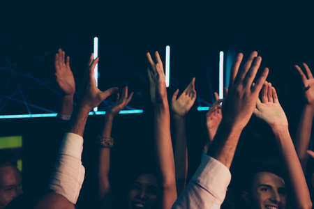 Diverse cheerful friends audience with raised hands .