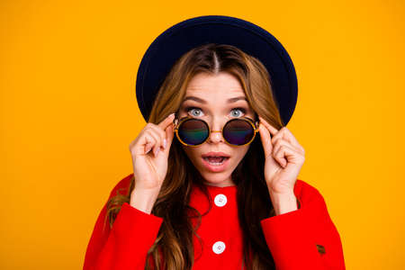 Woman wearing sun glasses  with orange background.