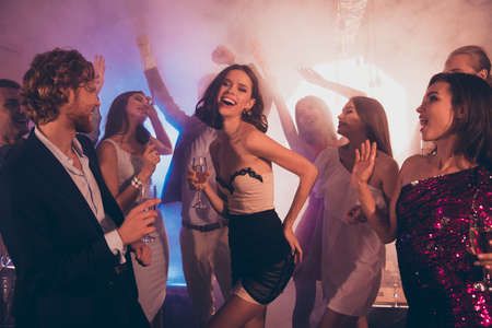 Happy, beautiful, attractive lady against dancing with friends