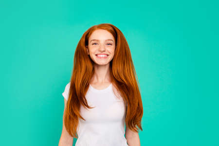 Portrait of careless, carefree, dreamy, dream, jump, jumper young girl make white smile isolated on vivid turquoise backgroundの写真素材