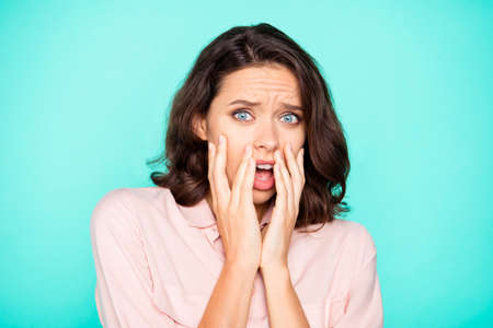 Portrait of nice pretty shocked worried girl opened mouth touching face isolated over turquoise teal...