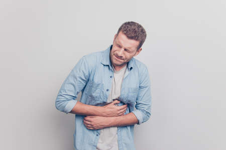 Photo of bad feelings man hold hand on stomach feel hard pain clの写真素材