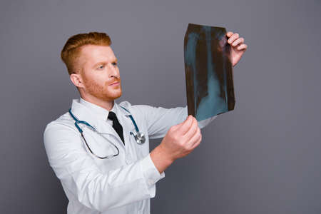 Portrait of calm doctor looking problem on image isolated on darの写真素材