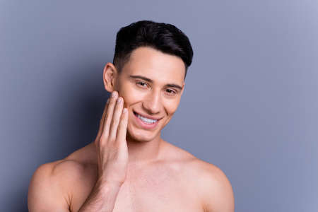 Close up portrait of nice lovely good-looking man touch cheek byの写真素材