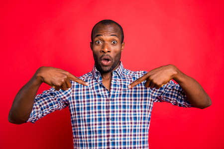 Portrait of nice cool trendy handsome cheerful cheery positive optimistic guy wearing checked shirt showing two forefingers at himself isolated over bright vivid shine red backgroundの写真素材