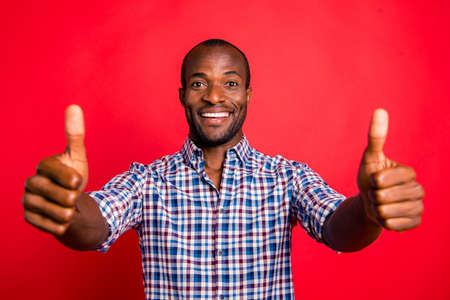 Portrait of nice cool handsome attractive cheerful positive guy wearing checked shirt showing double thumb-up isolated over bright vivid shine red backgroundの写真素材