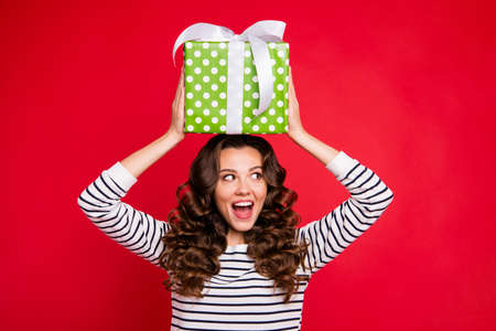 Portrait of nice cute winsome attractive cheerful wavy-haired lady wearing striped pullover holding...
