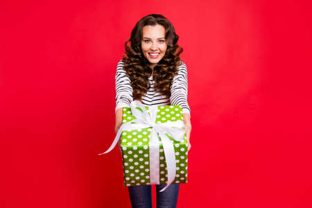 Portrait of nice cute winsome attractive cheerful wavy-haired lady wearing striped pullover holding...