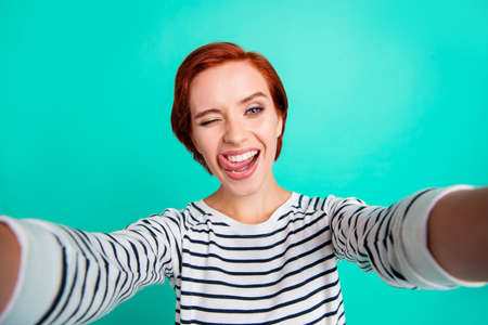 Closeup photo portrait of ecstatic lovely sweet optimistic cool swag with teeth she her lady student take make selfie om device smart phone video call isolated teal pastel backgroundの写真素材