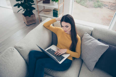 Top above high angle view of nice lovely cute sweet attractive adorable creative smart clever girl sitting on divan writing texts preparing presentation courses in light interior roomの写真素材