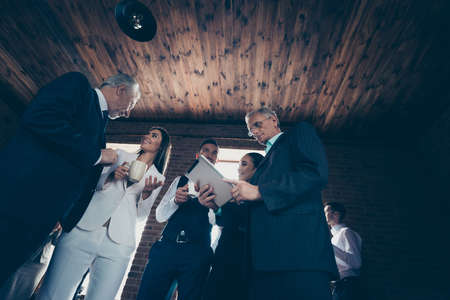 Low below angle view of nice cheerful positive elegant classy colleagues