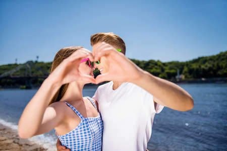 Romance feelings tenderness gentle concept. Close up photo of cheerful positive kind glad married spouses make showing small hear use hands having vacation resort travelの写真素材