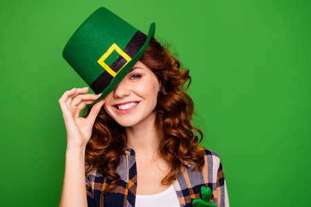 close up image of a lady with a green hat posing in the studio celebrating st. patrick's day. green backgroundの写真素材