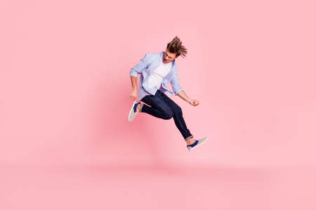 Full length body size photo of jumping high crazy he his him handsome holding imagine electric guitar in hands trying hard wearing casual jeans checkered plaid shirt isolated on rose backgroundの写真素材