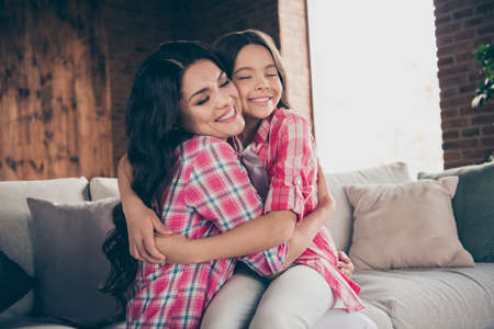 Portrait of nice-looking cute winsome delicate sweet tender gentle attractive charming cheerful kind wavy-haired people cuddling dear mom dream sitting on divan in houseの写真素材