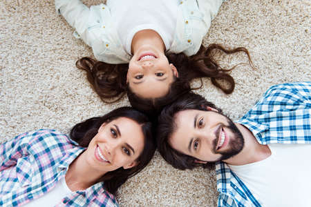 Close-up top above high angle view portrait of nice cute lovely friendly attractive kind cheerful cheery people mom dad lying on light carpet indoorsの写真素材