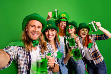 Self-portrait of nice cool attractive cheerful glad positive stylish people guys ladies wearing costumes holding clinking jar craft beer ale isolated over bright vivid shine backgroundの写真素材