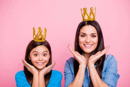 Close-up portrait of two nice cute sweet delighted pretty lovely attractive funny cheerful cheery positive glad straight-haired girls wearing crowns isolated over pink pastel backgroundの写真素材