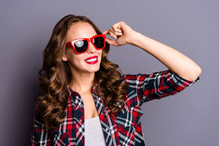 Close up portrait of an amazing  lady, hand on red dark bright summer glasses, wearing casual...