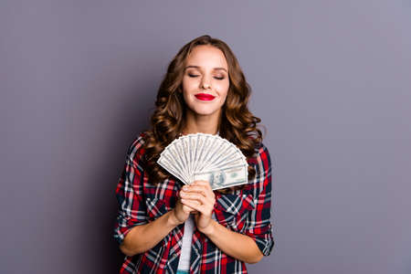 Close up portrait of an amazing  lady, money in hands, wearing casual checkered shirt isolated on...