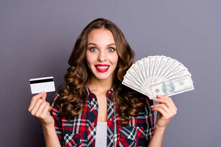 Close up portrait of an amazing  lady, money in hands, wearing casual checkered shirt isolated on...