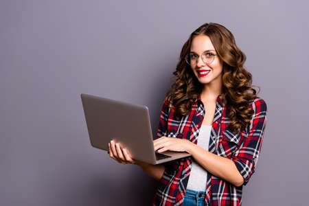 Close up portrait of amazing beautiful she her lady laptop sending sms friends check email people person wearing specs checkered plaid shirt outfit clothes isolated on grey backgroundの写真素材